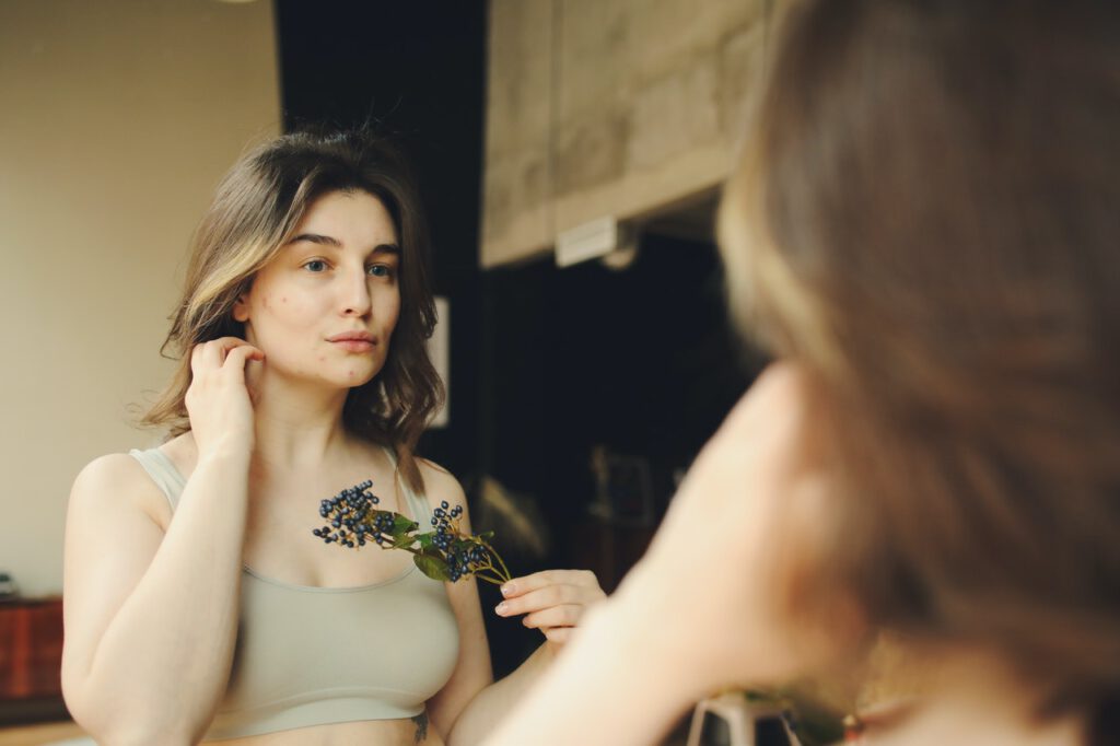 Woman with breast pimples holding flower in her hand