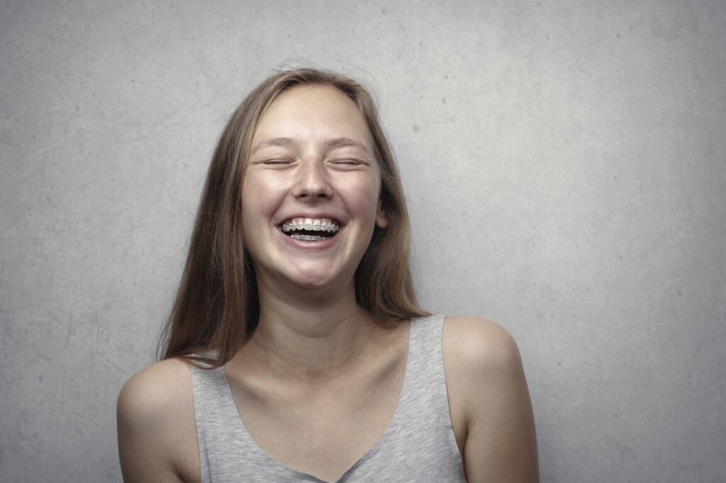 Woman wearing braces seems to be happy because is laughing