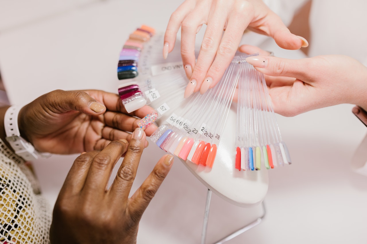 Woman at the nail salon is choosing her new nail color